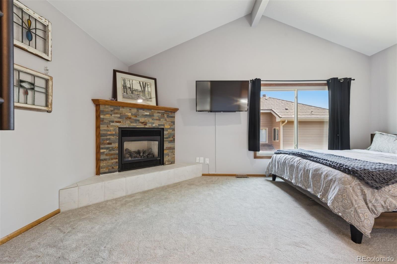 23860 Genesee Village Road Golden, CO 80401 - Photo 17 of 36 a spacious bedroom with a bed and a fireplace