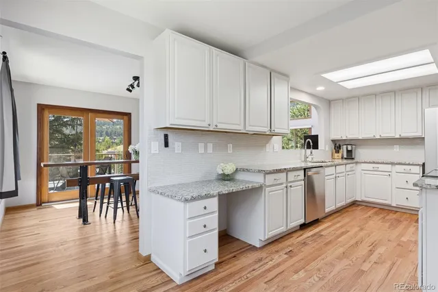 a kitchen with a wooden floor window and chairs