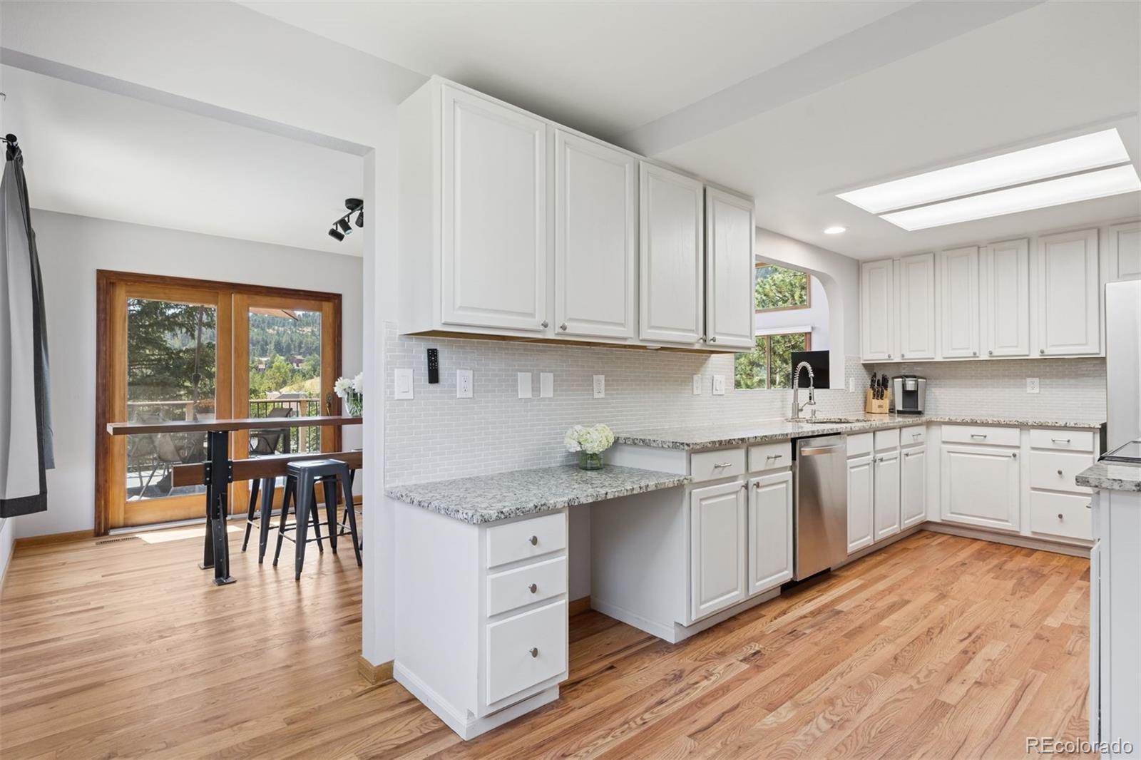 23860 Genesee Village Road Golden, CO 80401 - Photo 3 of 36 a kitchen with a wooden floor window and chairs