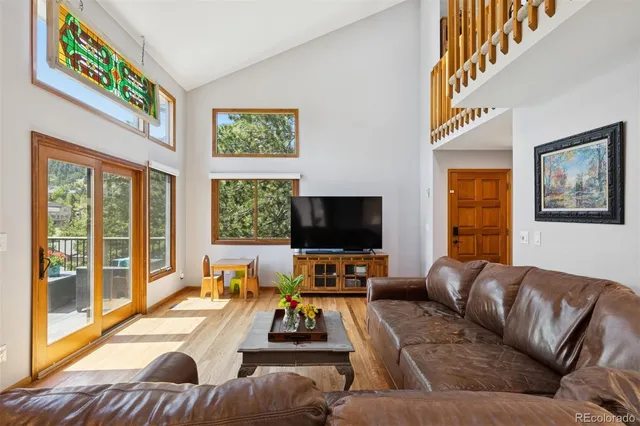 a living room with furniture and a flat screen tv with wooden floor