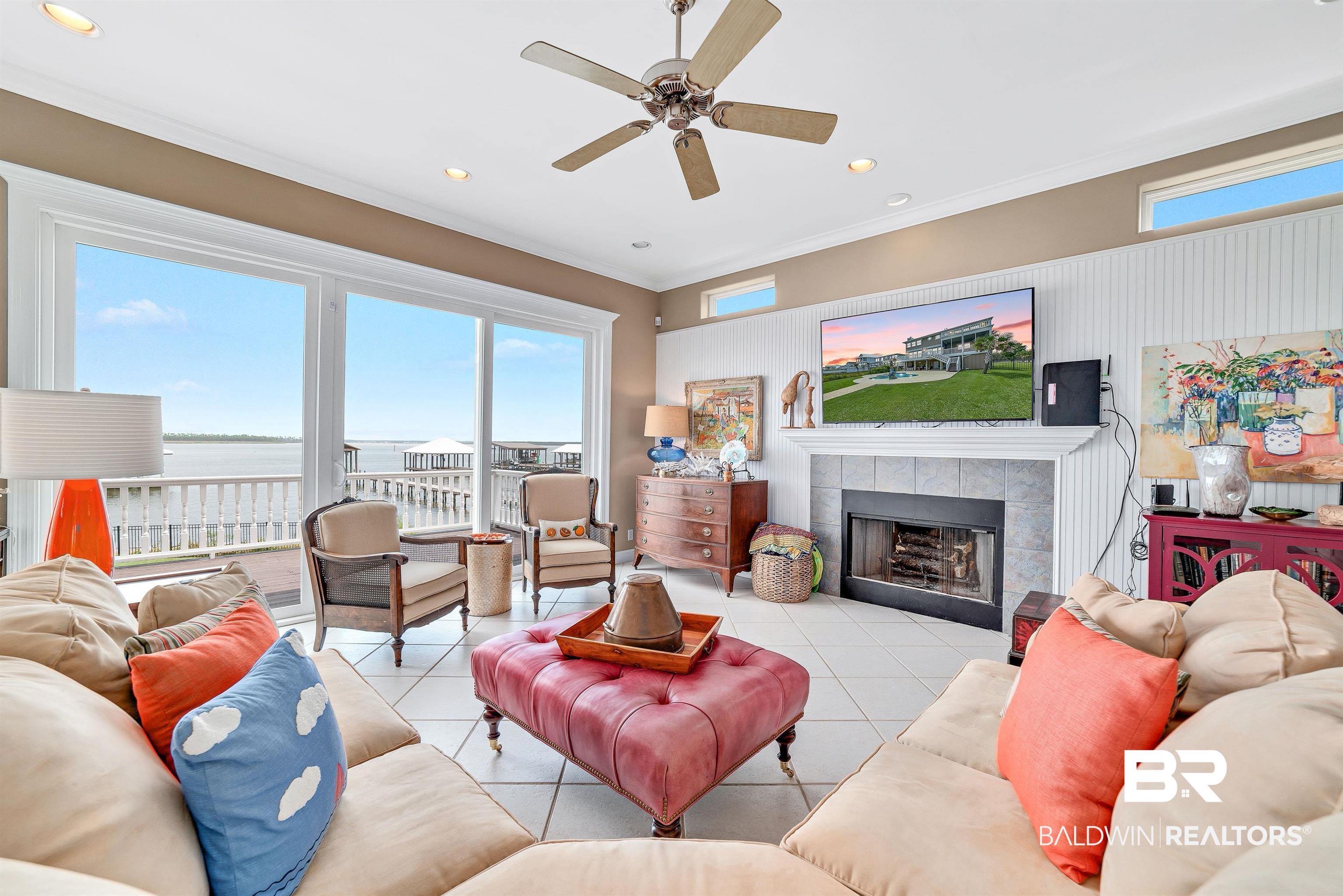 24513 Gulf Bay Road Orange Beach, AL 36561 - Photo 4 of 52 Tiled living room with a fireplace, crown molding, and ceiling fan