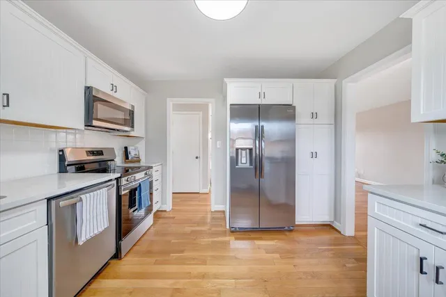 a kitchen with stainless steel appliances granite countertop a refrigerator a stove and a sink