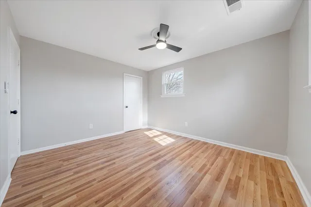 a view of empty room with wooden floor