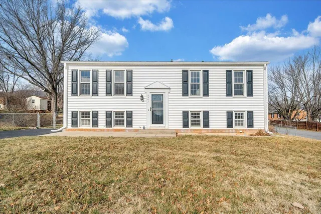 a view of residential houses with yard and trees