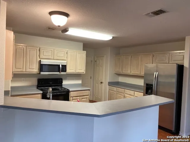 a kitchen with stainless steel appliances a refrigerator a stove a microwave and cabinets