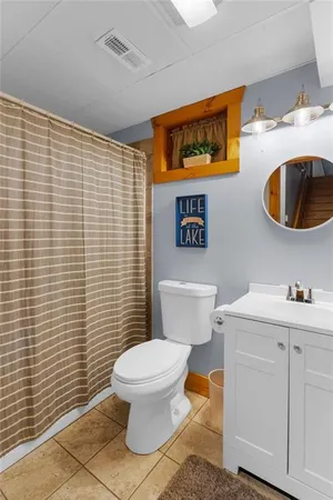 a white toilet sitting next to a bathroom sink and a window