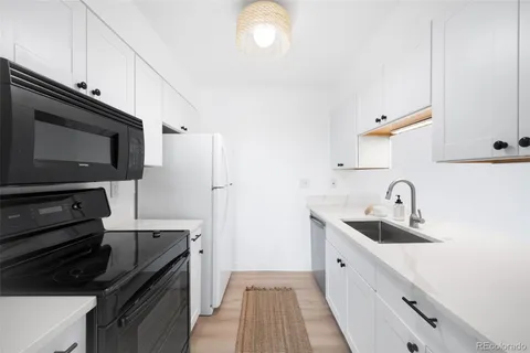 a kitchen with stainless steel appliances a sink a stove and cabinets