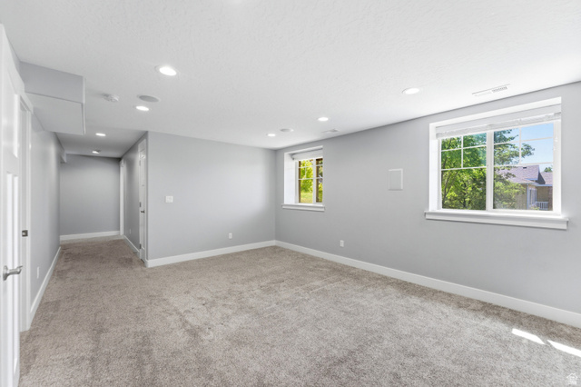 1614 Aspen Loop Provo, UT 84606 - Photo 31 of 47 Spacious room featuring light gray walls, plush carpeting, multiple recessed lights, and two windows with white trim