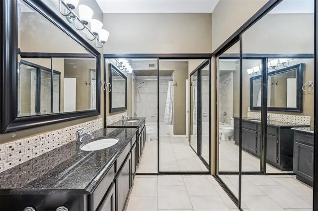 a bathroom with a granite countertop sink a mirror and shower