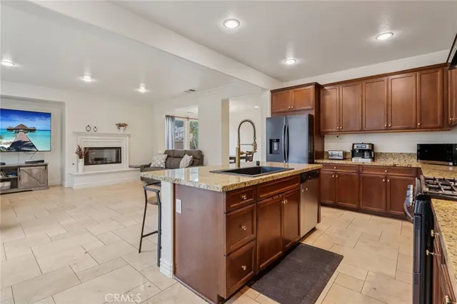 a kitchen with stainless steel appliances granite countertop a stove a sink and a refrigerator