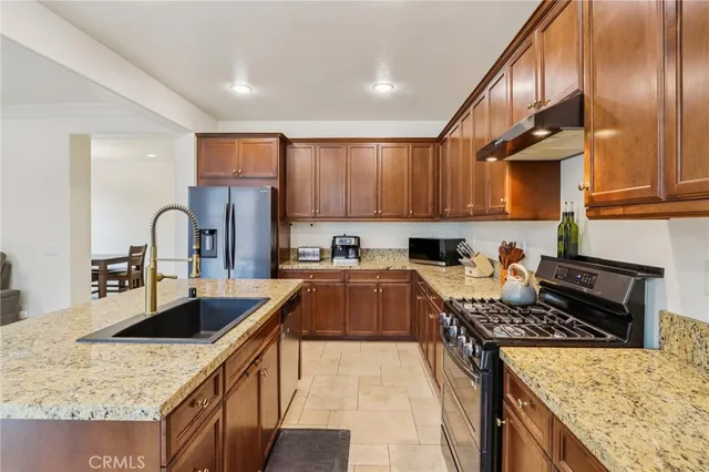 a kitchen with stainless steel appliances granite countertop a sink stove and refrigerator
