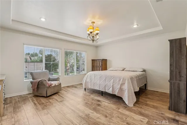 a spacious bedroom with a bed and a chandelier