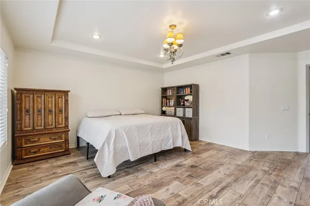 a spacious bedroom with a bed and a chandelier