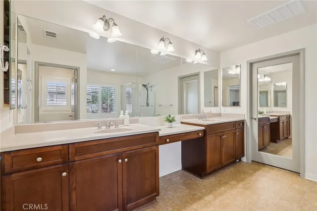 a spacious bathroom with a granite countertop double vanity and a large mirror