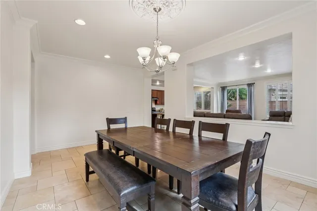 a dining room with wooden floor a chandelier a wooden table and chairs