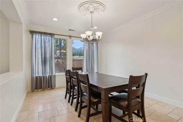 a dining room with furniture a chandelier and a rug