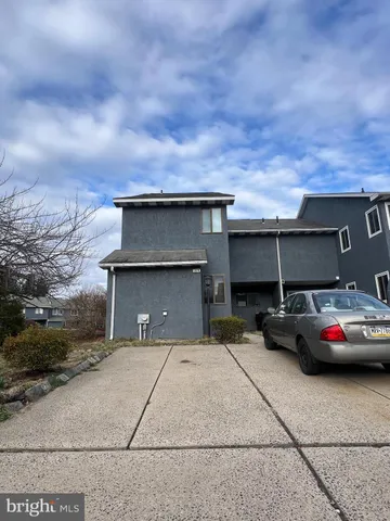 a front view of a house with cars parked