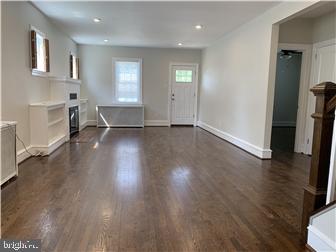 905 Rodman Road Bellefonte, DE 19809 - Photo 2 of 25 an empty room with wooden floor and windows