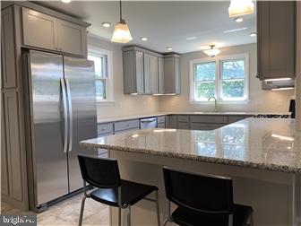 905 Rodman Road Bellefonte, DE 19809 - Photo 4 of 25 a kitchen with granite countertop a counter space cabinets and stainless steel appliances