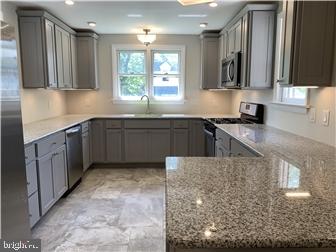 905 Rodman Road Bellefonte, DE 19809 - Photo 7 of 25 a kitchen with stainless steel appliances granite countertop a sink stove and cabinets