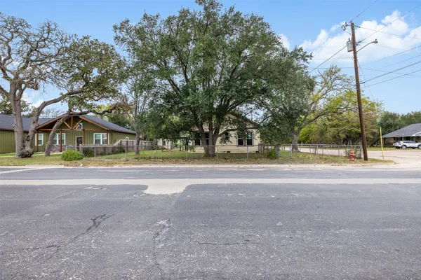 a view of a house with a yard and a large tree