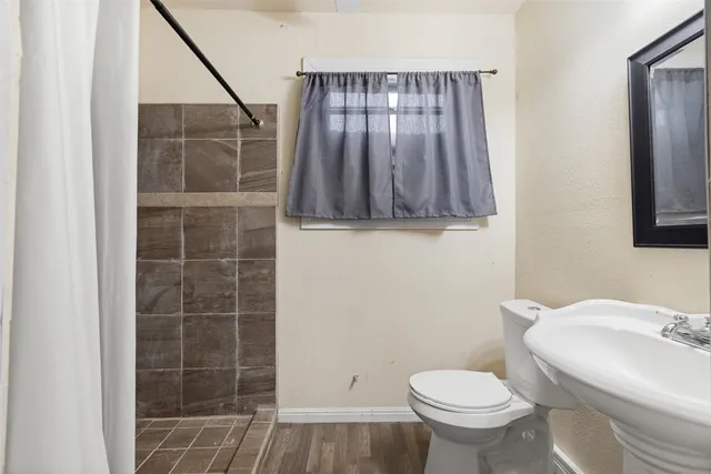 a bathroom with a toilet a sink and mirror
