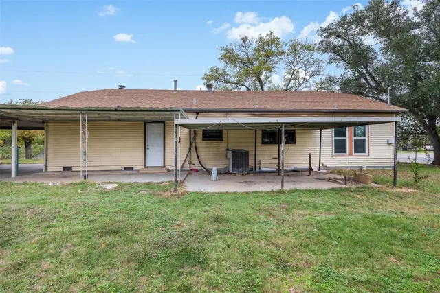 a view of a house with backyard and a tree