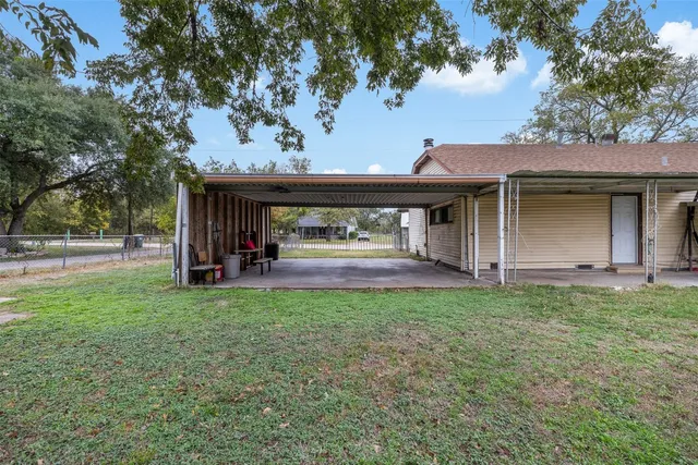 a view of backyard with wooden fence and large trees
