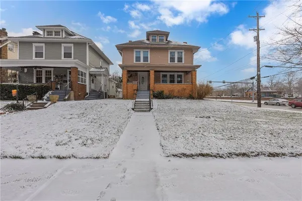 a front view of a house with a yard covered in snow