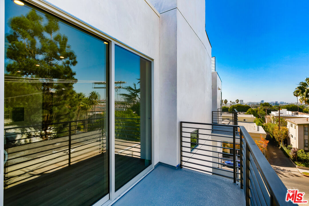 12431 Rochester Avenue, Unit PH7 Los Angeles, CA 90025 - Photo 11 of 23 a view of a balcony with chairs and iron stairs