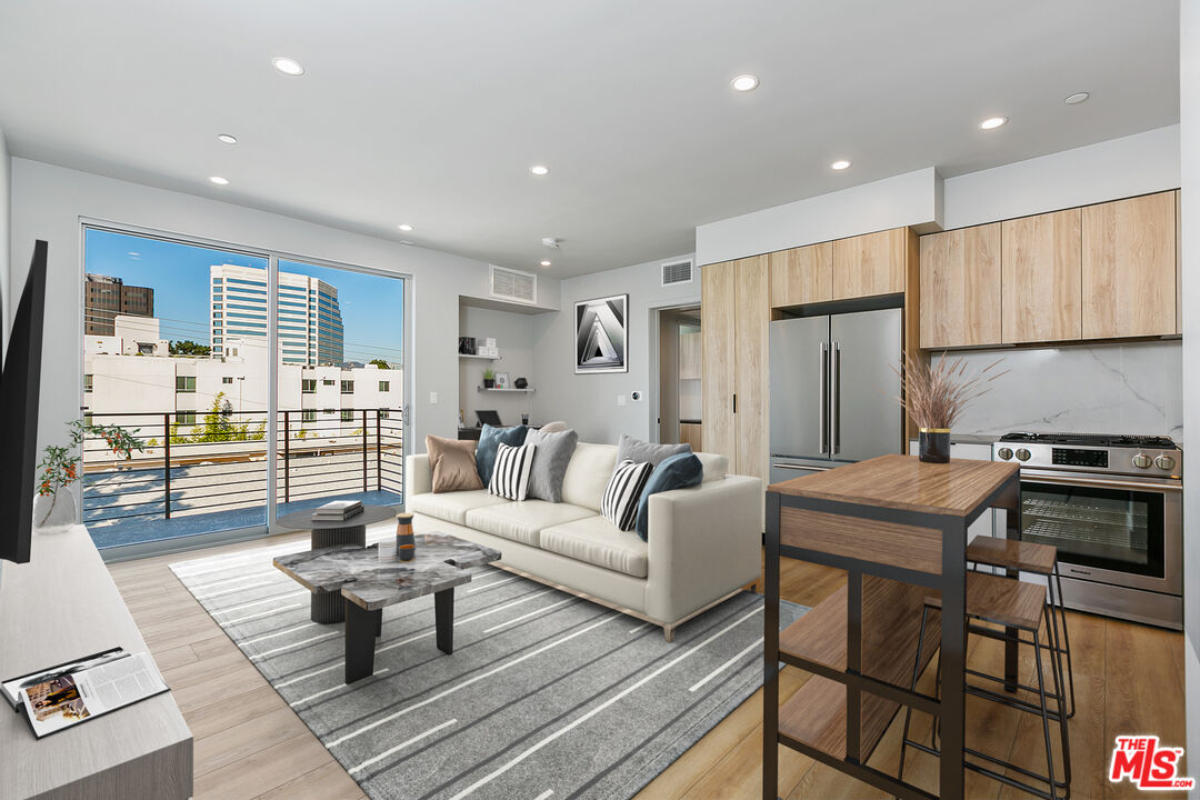 12431 Rochester Avenue, Unit PH7 Los Angeles, CA 90025 - Photo 2 of 23 a living room with furniture a rug and a table