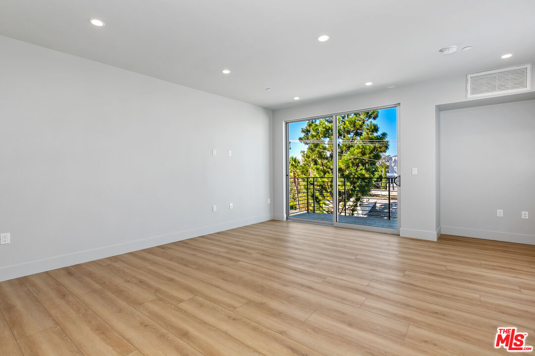 12431 Rochester Avenue, Unit PH7 Los Angeles, CA 90025 - Photo 5 of 23 a view of room with wooden floor and window