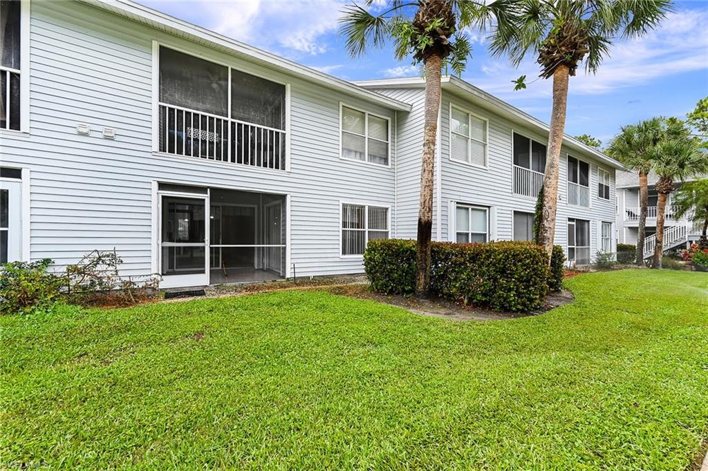 1933 Courtyard Way, Unit D103 Naples, FL 34112 - Photo 19 of 24 a house that has a tree in front of it