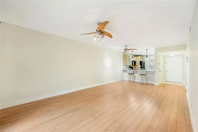 a view of a kitchen with wooden floor and a ceiling fan