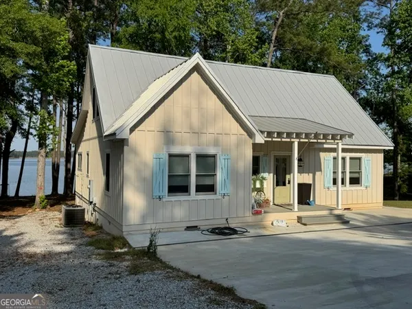 a view of a white house with a outdoor space and trees