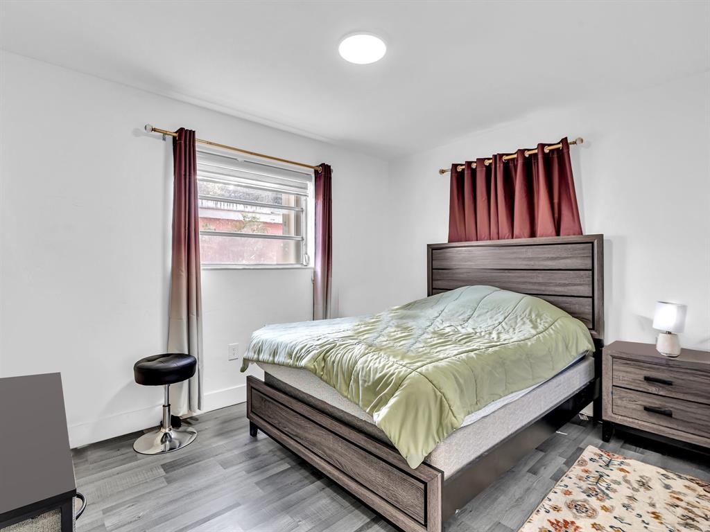 1052 Northwest 103rd Street Miami, FL 33150 - Photo 14 of 40 a bedroom with a bed and wooden floor