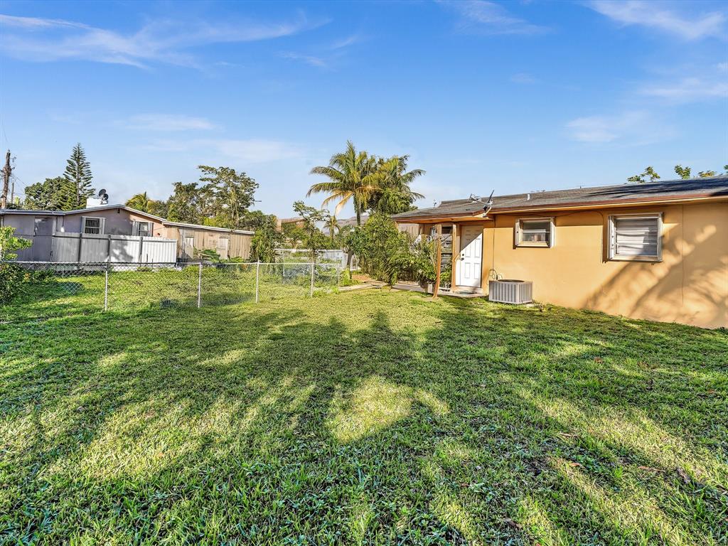 1052 Northwest 103rd Street Miami, FL 33150 - Photo 19 of 40 a backyard of a house with lots of green space and garden view