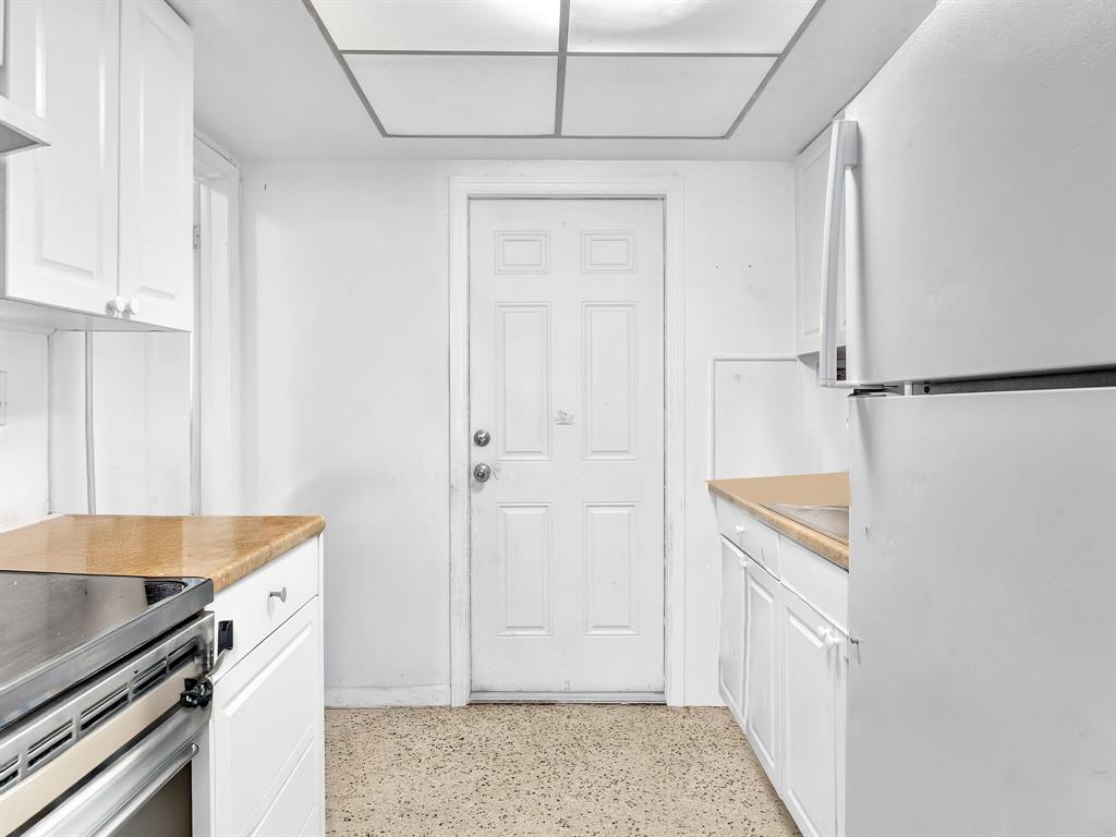 1052 Northwest 103rd Street Miami, FL 33150 - Photo 26 of 40 a kitchen with a refrigerator and white cabinets