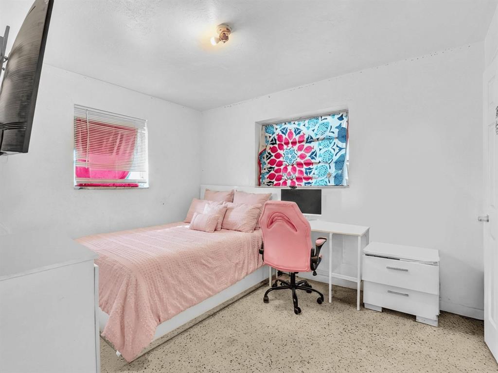 1052 Northwest 103rd Street Miami, FL 33150 - Photo 31 of 40 a bedroom with a bed and a desk