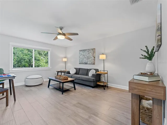 an empty room with a window and a ceiling fan