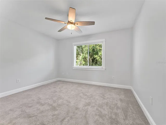 an empty room with chandelier fan
