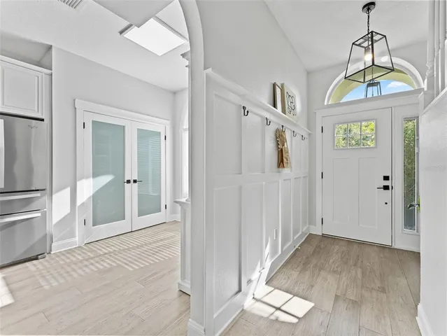a view of a hallway with wooden floor and windows