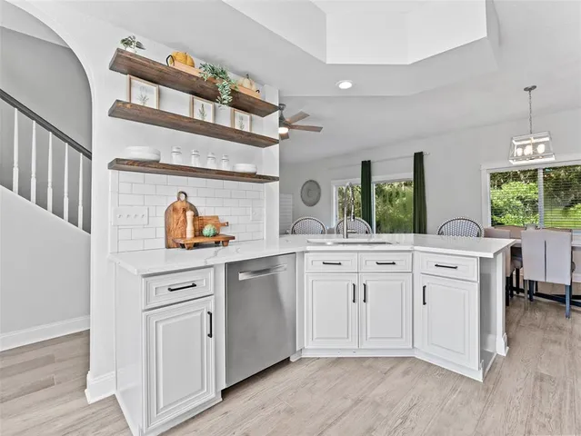 a kitchen with white cabinets and sink