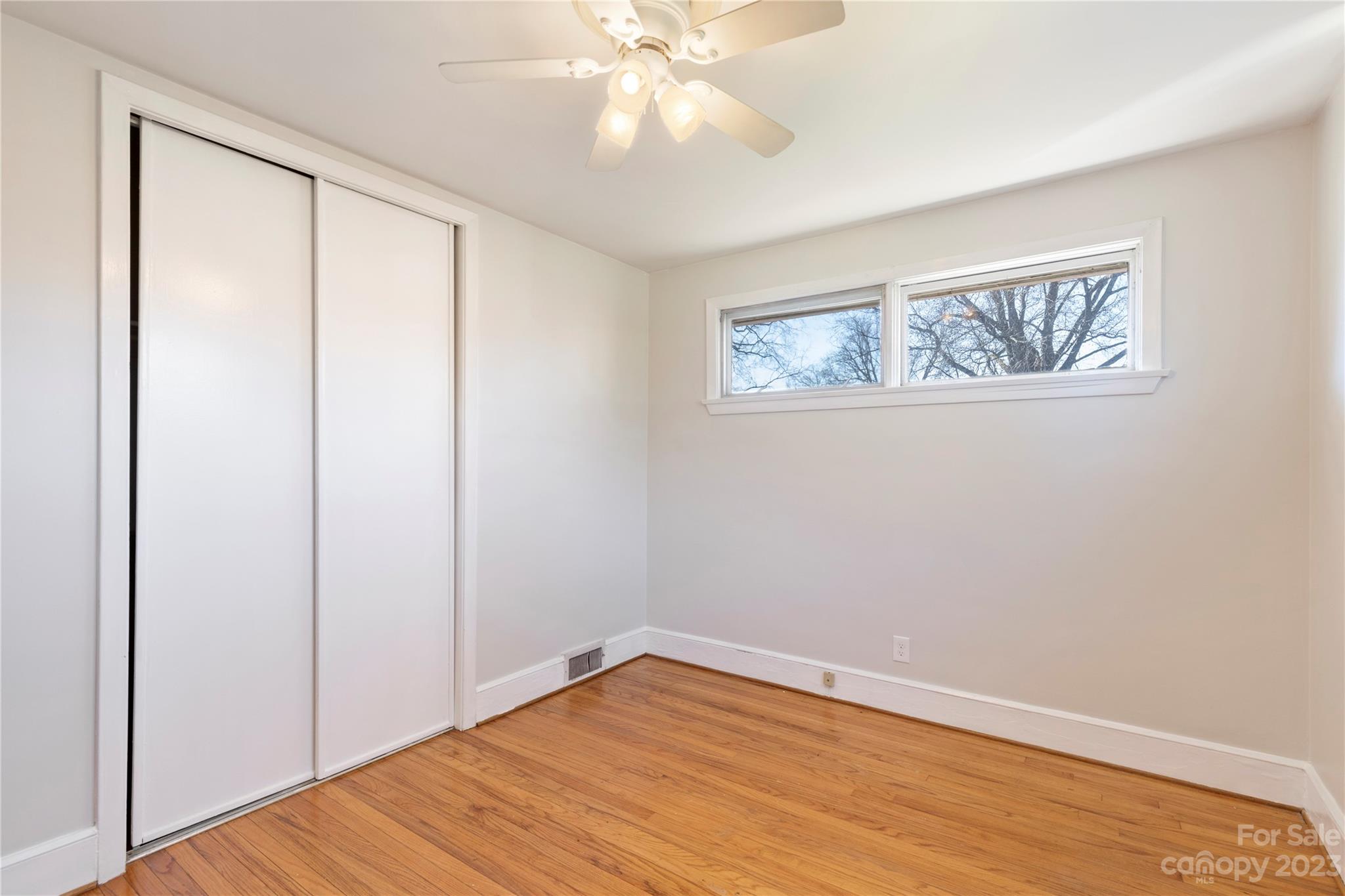 350 South Sharon Amity Road Charlotte, NC 28211 - Photo 17 of 21 a view of an empty room with wooden floor and a ceiling fan