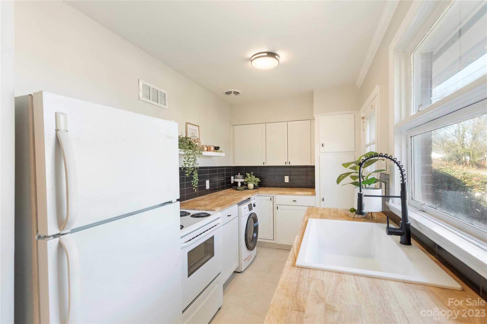 350 South Sharon Amity Road Charlotte, NC 28211 - Photo 8 of 21 a kitchen with stainless steel appliances a refrigerator sink and white cabinets