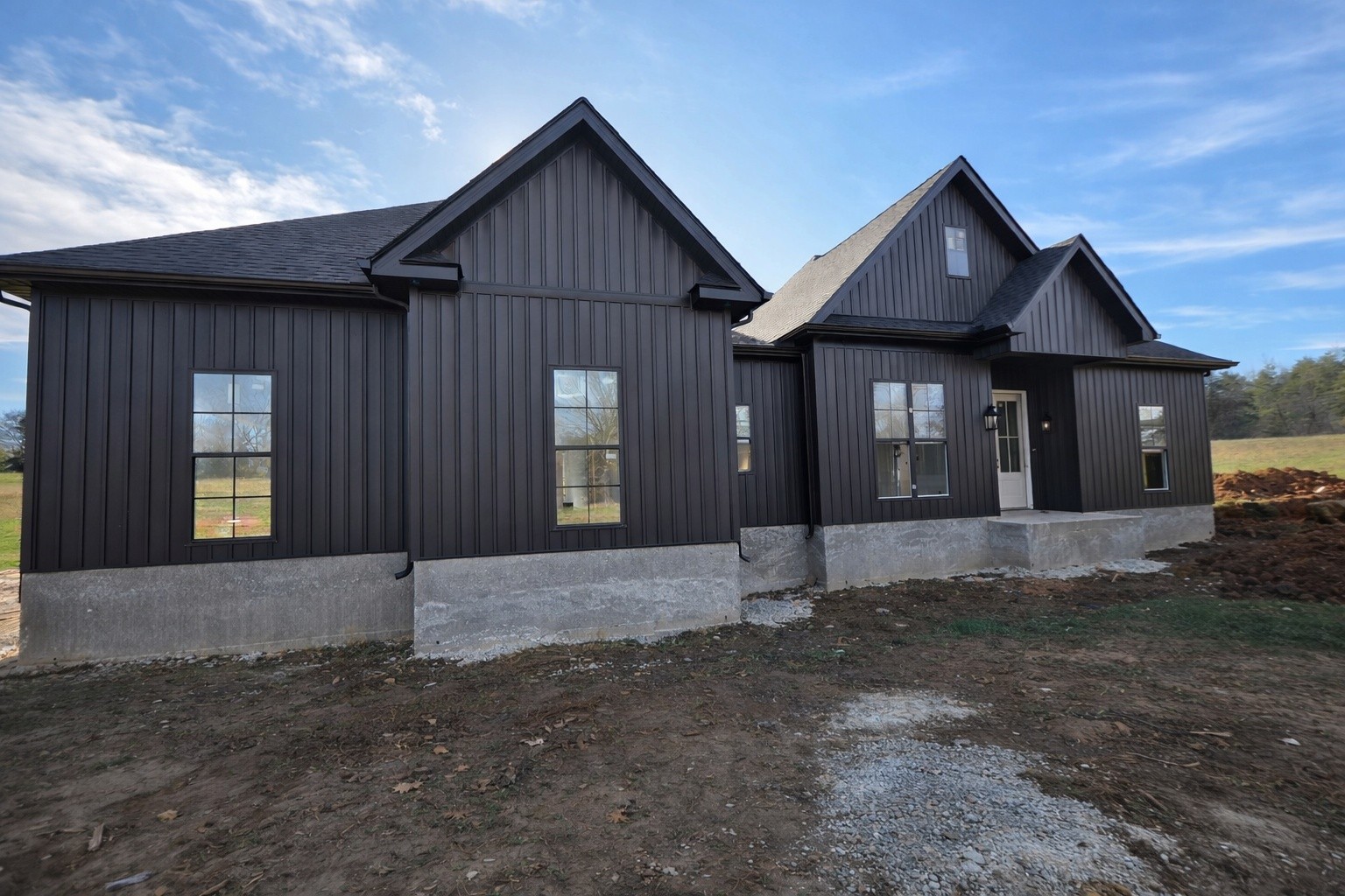 a view of a brick house next to a yard with large trees