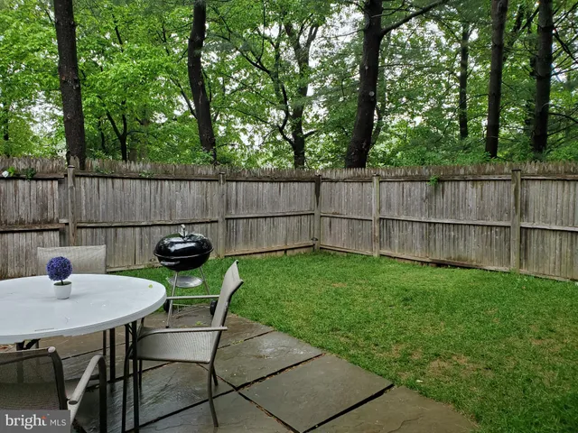 a view of a backyard with table and chairs and a barbeque
