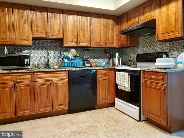 a kitchen with stainless steel appliances granite countertop a stove sink and cabinets