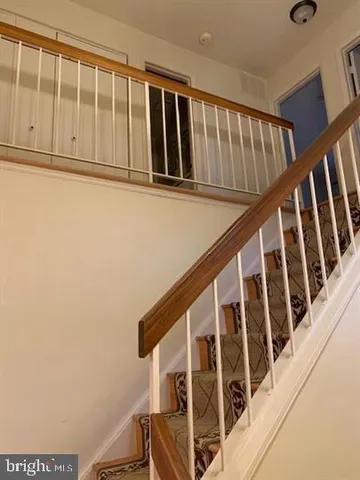 a view of staircase with railing and white walls