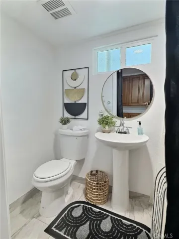 a bathroom with a sink toilet and mirror